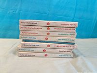 Stack of eight Charlie Brown hardcover books showing uniform spines and titles
