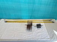 Overview of five rods and two brush heads on table