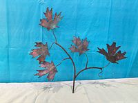 Front view of copper maple leaf sculpture showing seven leaves and branching rod