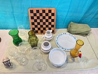 Grouped shot of game board, colored vases, tumblers, Pyrex dishes, napkins