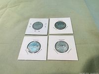 Front view of four 1967 Canadian bobcat quarters in flips