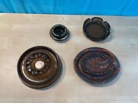 Top view of all four ashtrays showing shapes, colors, materials
