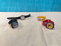 Group shot of four Swatch watches showing overall condition and variety