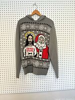 Front view showing full sweater, hood, snowflake pattern and humorous Jesus and Santa graphic