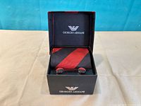 Closed Giorgio Armani box displaying tie and cufflinks inside