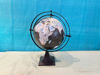 Front view of black globe on stand