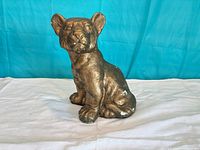Front view of gold painted seated lion figurine showing overall form and finish