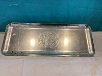 Top view of metal tray showing Indigenous motif and border