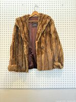 Front view of brown fur coat showing collar, button, lining