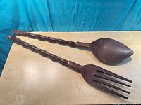 Full view of both large carved wooden fork and spoon