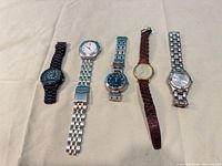 Group shot of five men’s wristwatches laid side by side