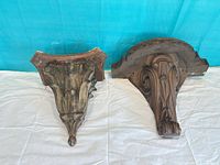 Front view of both sconces showing decorative carvings and size comparison