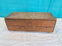Front view of closed pine storage box showing drawer and knobs