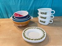 Stack of Pyrex bowls, Spring Blossom pour spout cups and Corelle plate visible
