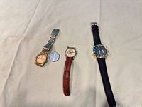 Group shot of three wristwatches and one loose watch head