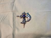 Front view showing complete pendant design and blue cabochon