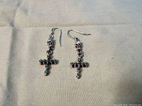 Front view of both dangle earrings highlighting skull and cross design