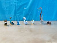 All seven glass figurines lined up left to right