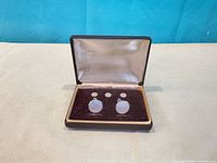 Open case showing cufflinks and studs