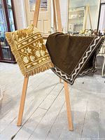 Both table runners draped over stand showing patterns, fringe, lace trim and overall size