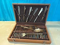 Open wooden case showing all utensils arranged in slots