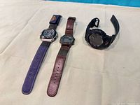 Three Casio watches laid out showing fronts and straps