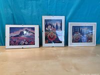 All three framed prints standing on table