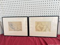 Both framed charcoal drawings side by side showing frames and mats