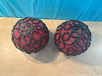 Top view of both red fiberglass lamp shades showing black lattice pattern