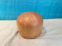 Front view of wooden hat mold showing overall form