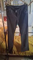 Front view of brown velvet pants hanging