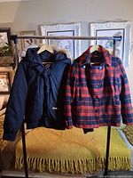 Front view of both jackets hanging on rack