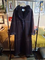 Front view of Alfred Sung faux suede long coat on hanger showing full length and faux fur trim