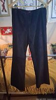 Full front view of black suede pants hanging