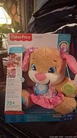 Front of sealed box showing Fisher-Price French talking rabbit toy and key features