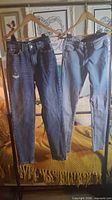 Front view of both pairs of jeans hanging on hangers