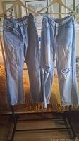 Both pairs of jeans hanging front view