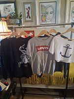 four tops hanging on rack showing overall lot