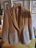 Front view of camel blazer on hanger