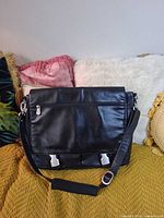 Front view showing flap, zip pocket and buckles