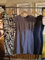 Overview of three dresses hanging on rack