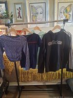 Four tops hanging on rack