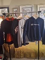 Rack displaying four XL hoodies/sweatshirts