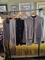 Four long-sleeve tops hanging on rack