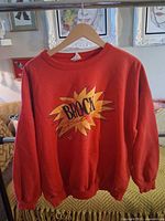 Full view of red Brock Busters sweatshirt on hanger