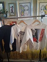 Three sweatshirts on hangers: black, white basketball graphic, cream Arizona State.