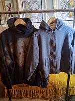 Front view of both hoodies on hangers