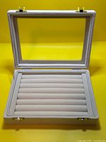 Case open showing interior ring tray and glass lid