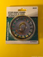 Front of sealed Moen M2225 kitchen basket strainer packaging