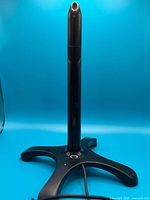 Full view of Fleshlight Sleeve Warmer on stand against blue background